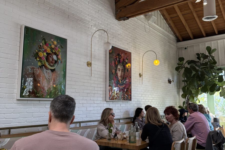 Busy restaurant dining room with guests at long wooden tables
