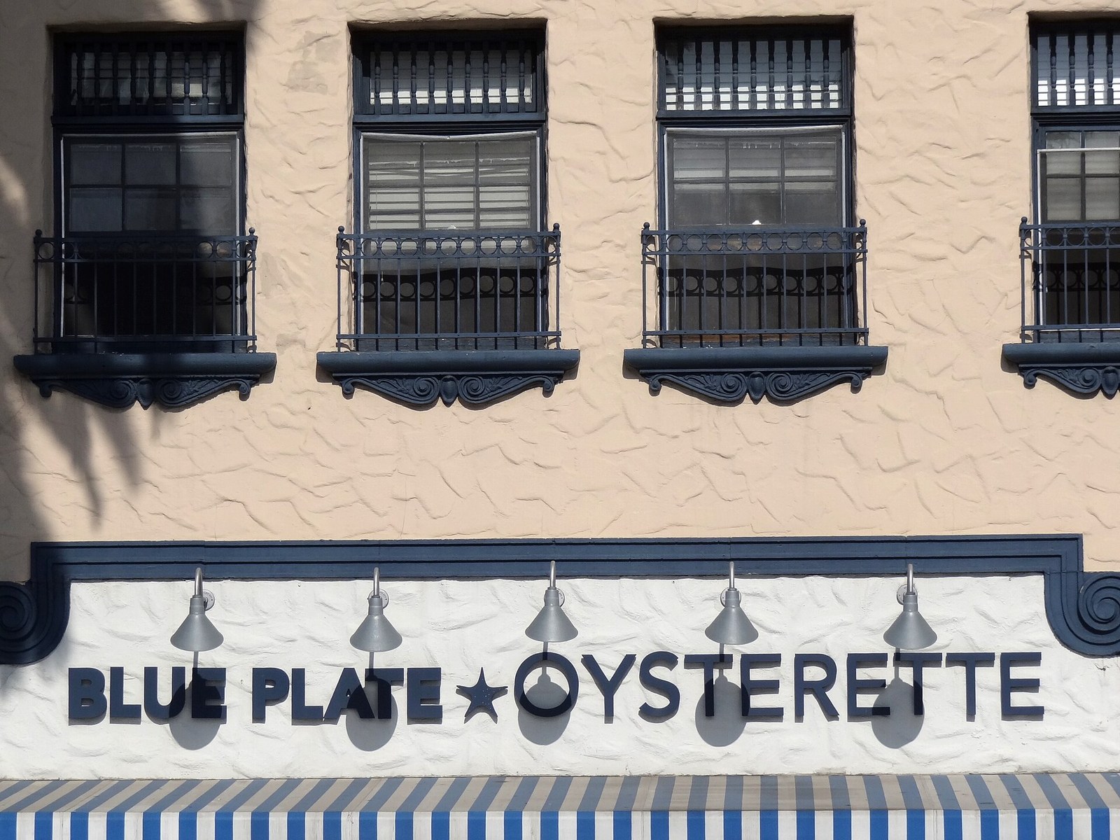Blue Plate Oysterette facade lettering and gooseneck lamps on Ocean Avenue, Santa Monica