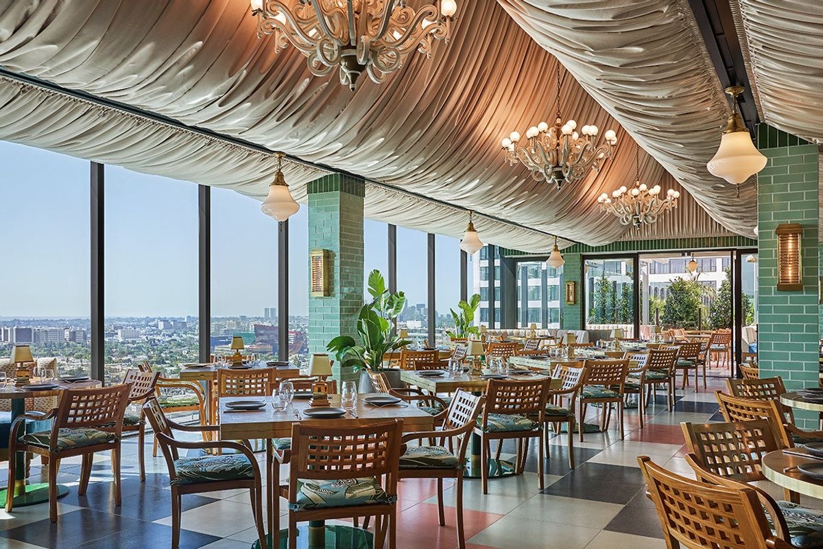 Merois rooftop dining room with draped ceiling, chandeliers, and LA skyline windows